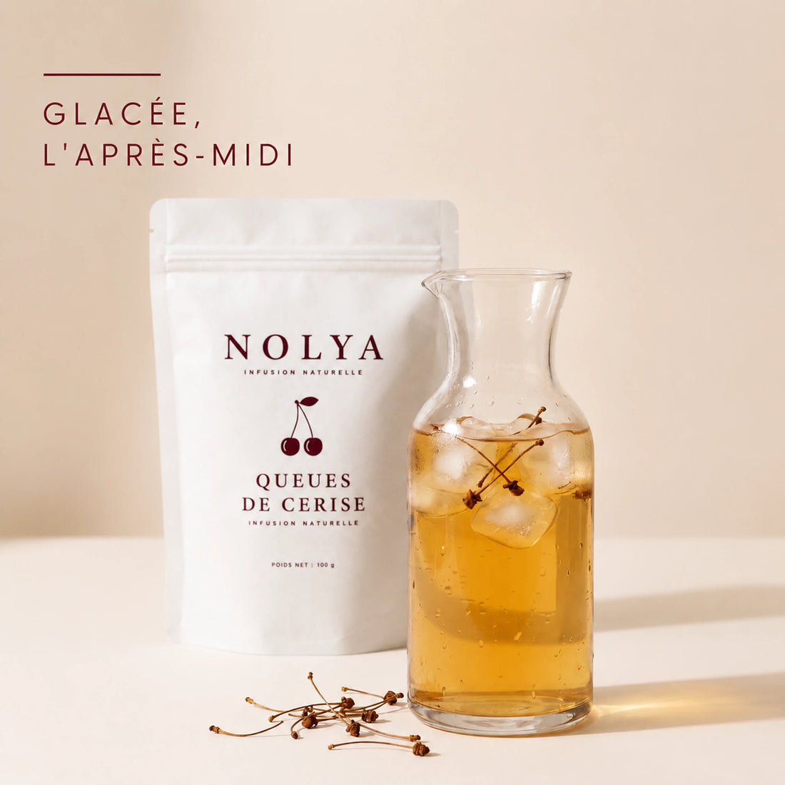 Carafe d'infusion glacée aux queues de cerise avec des glaçons, boisson fraîche de l'après-midi