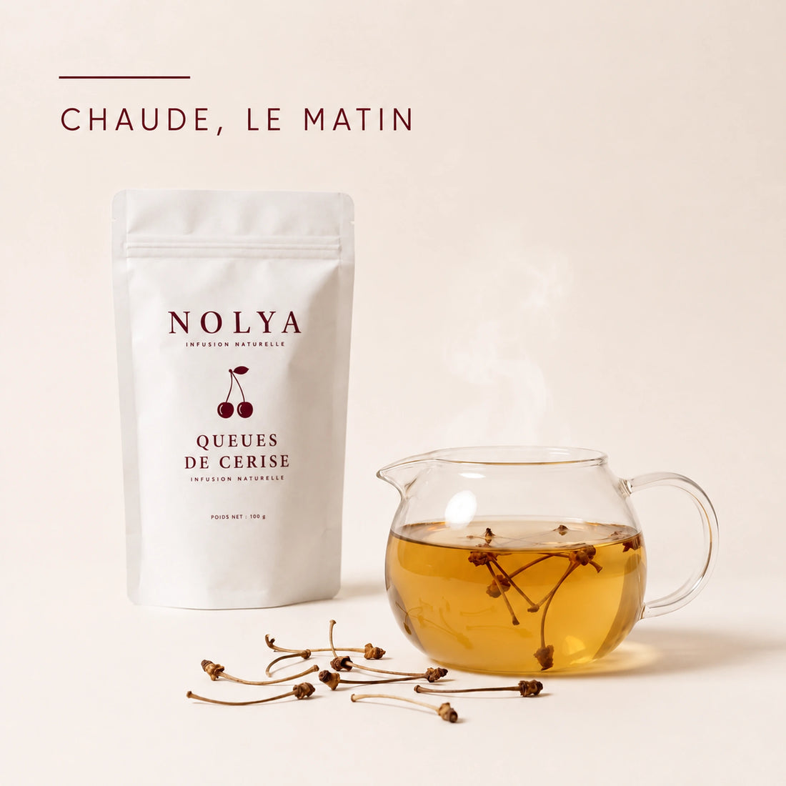 Théière en verre remplie d'une tisane chaude aux queues de cerise, le matin