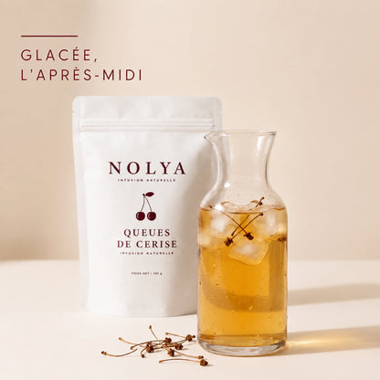 Carafe d'infusion glacée aux queues de cerise avec des glaçons, boisson fraîche de l'après-midi
